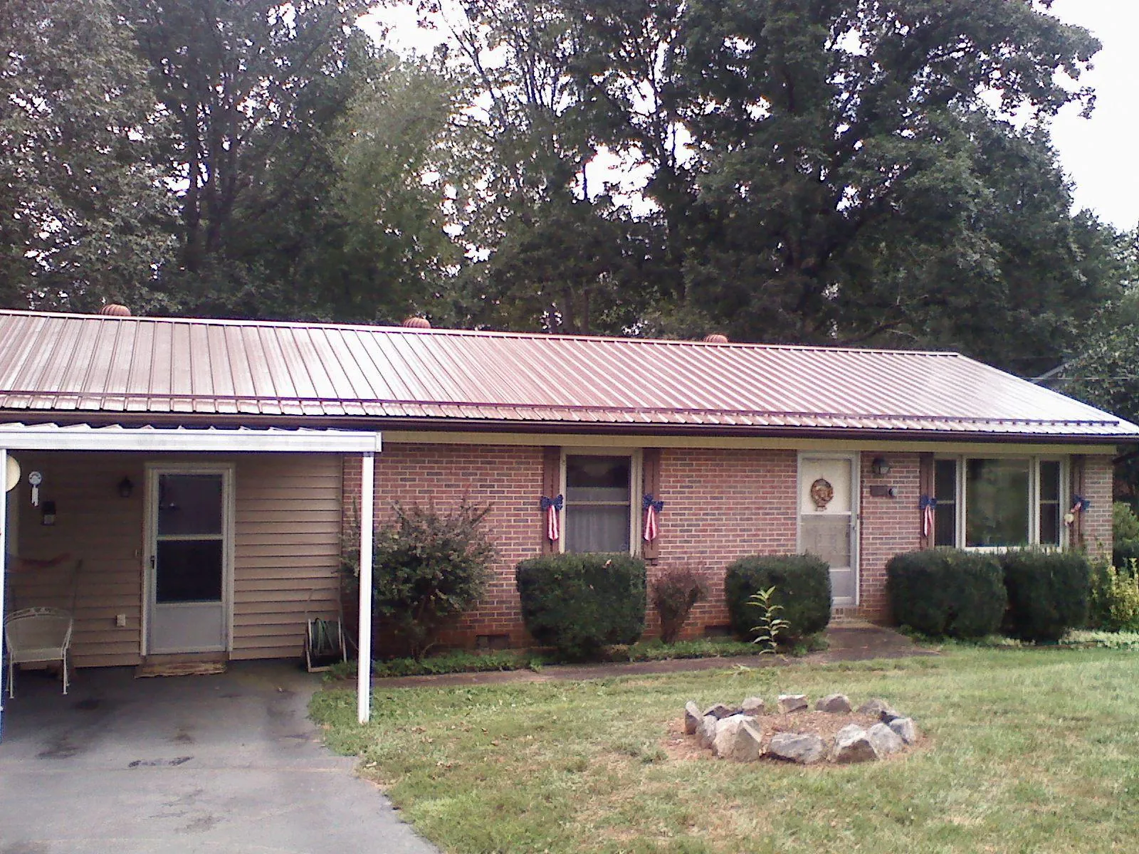 Bronze metal roof and carport on a brick ranch home — Roof Repair work by our crew in Houlka